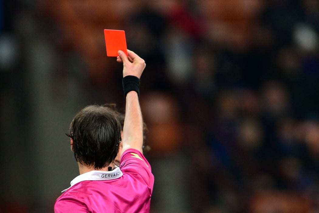 Atalanta's Italian midfielder Cristian Raimondi (hidden, background) receives a yellow card from the referee Andrea Gervasoni (front) during the Italian Serie A football match between Inter Milan and Atalanta on April 7, 2013 at the San Siro Stadium in Milan. Atalanta won 4-3. AFP PHOTO / GIUSEPPE CACACE (Photo by GIUSEPPE CACACE / AFP)