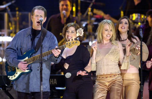 Former Beach Boy Brian Wilson (L) is joined on stage by the members of Wilson Phillips, his daughters Carney Wilson (2nd from L) and Wendy Wilson (R), and Chyna Phillips (2nd from R), during the final song in the Brian Wilson tribute at the Radio City Music Hall in New York 29 March, 2001. Wilson Phillips performed for the first time in 10 years during the tribute.   AFP PHOTO  Henny Ray ABRAMS (Photo by HENNY RAY ABRAMS / AFP)