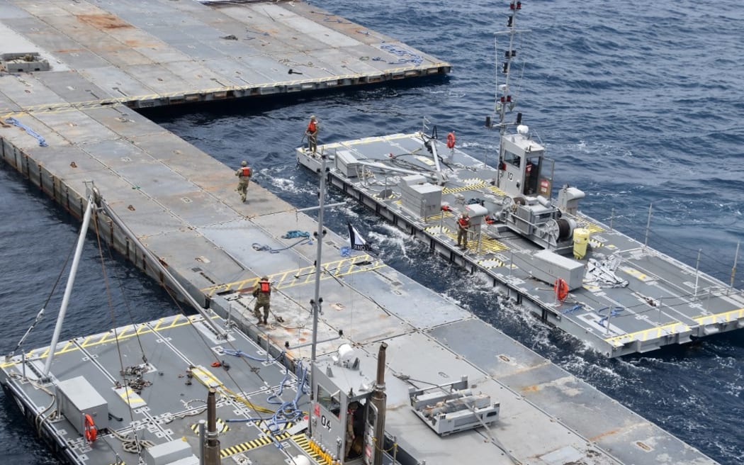 This handout picture courtesy of the US Central Command (CENTCOM) taken on April 26, 2024 shows construction work on the floating Joint Logistics Over-The-Shore (JLOTS) pier in the Mediterranean Sea, which will support the US Agency for International Development (USAID) and partners to receive and deliver humanitarian aid to the Gaza Strip. (Photo by US Central Command (CENTCOM) / AFP) / RESTRICTED TO EDITORIAL USE - MANDATORY CREDIT "AFP PHOTO / US Central Command (CENTCOM) - NO MARKETING NO ADVERTISING CAMPAIGNS - DISTRIBUTED AS A SERVICE TO CLIENTS