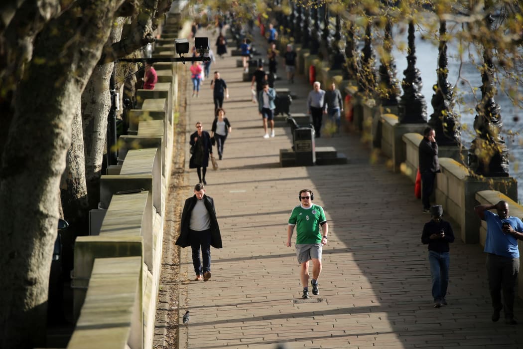 People walk, run and jog along the South Bank, by the River Thames, to take their daily exercise allowance in central London on April 7, 2020, as life in Britain continues during the nationwide lockdown to combat the novel coronavirus pandemic.