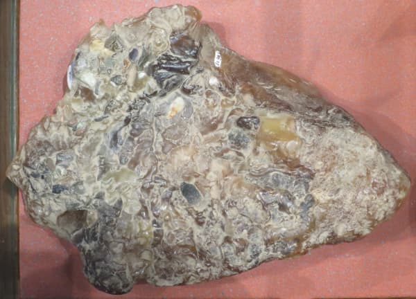 A dried clump of ambergris that looks like an amalgamation of small grey stones.