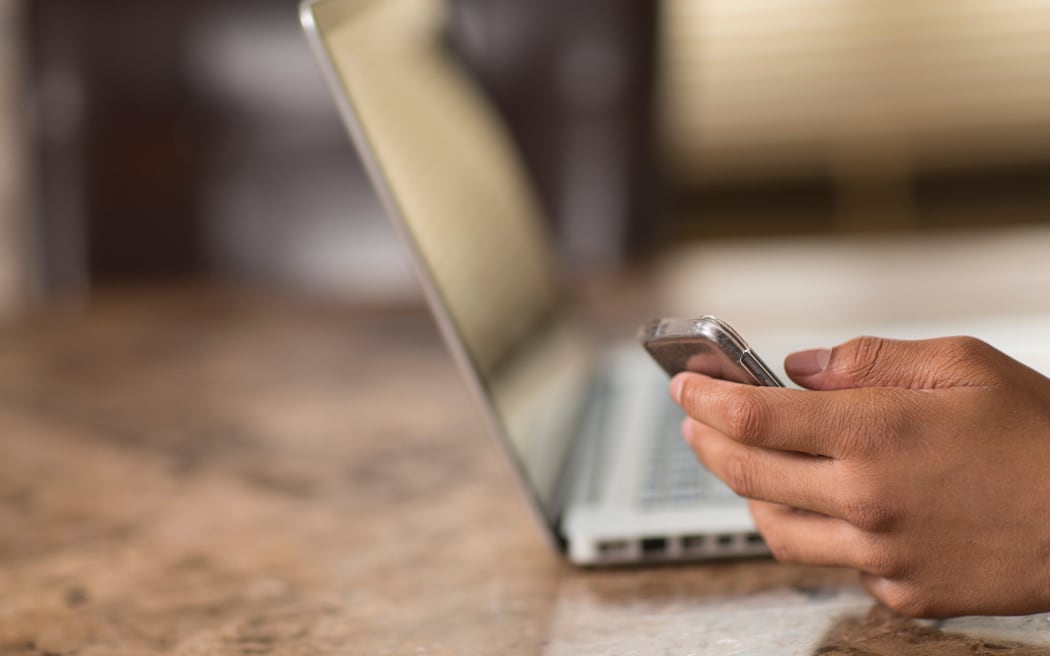 Teenager uses phone and laptop internet