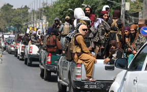 A convoy of Taliban fighters patrol along a street in Kabul
