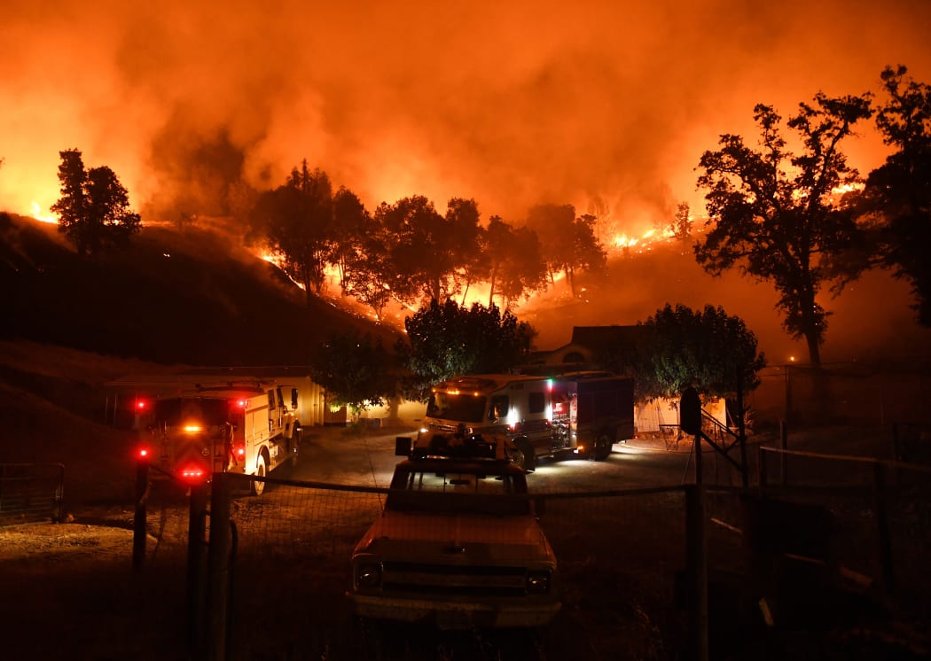 Firefighters conduct a controlled burn to defend houses against flames from the Ranch Fire.