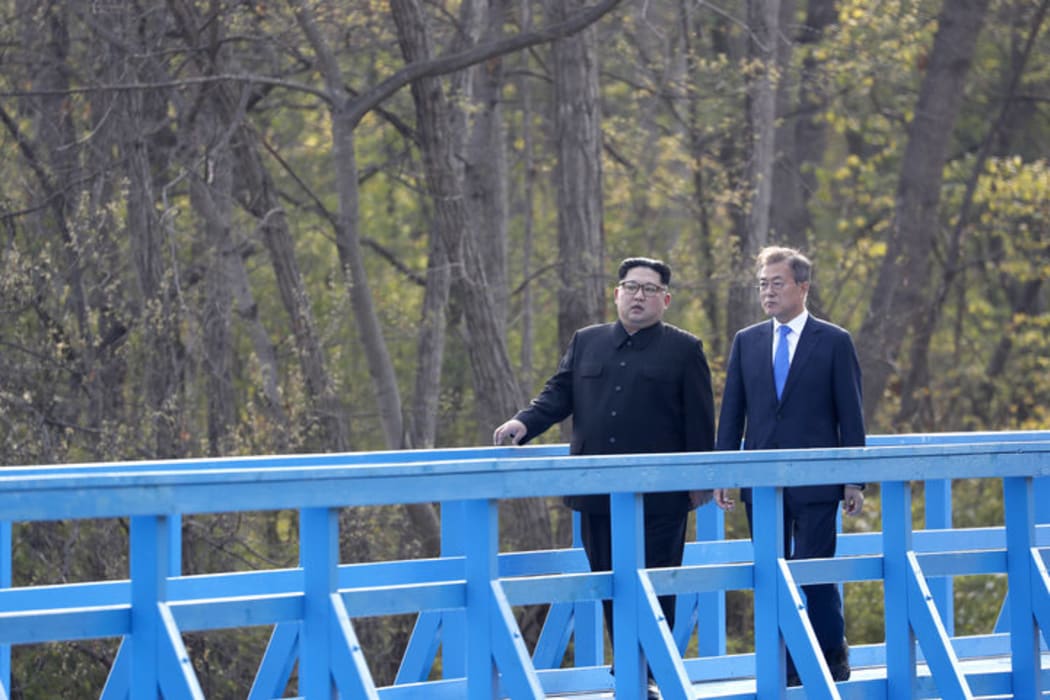 North Korea's leader Kim Jong Un (L) and South Korea's President Moon Jae-in (R) walk on a bridge after a tree-planting ceremony at the truce village of Panmunjom