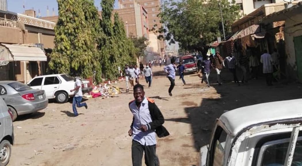 Sudanese protesters run away from tear gas smokes during a demonstration in Khartoum, on December 31, 2018.