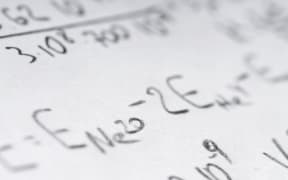 Maths book open with math problems written down
