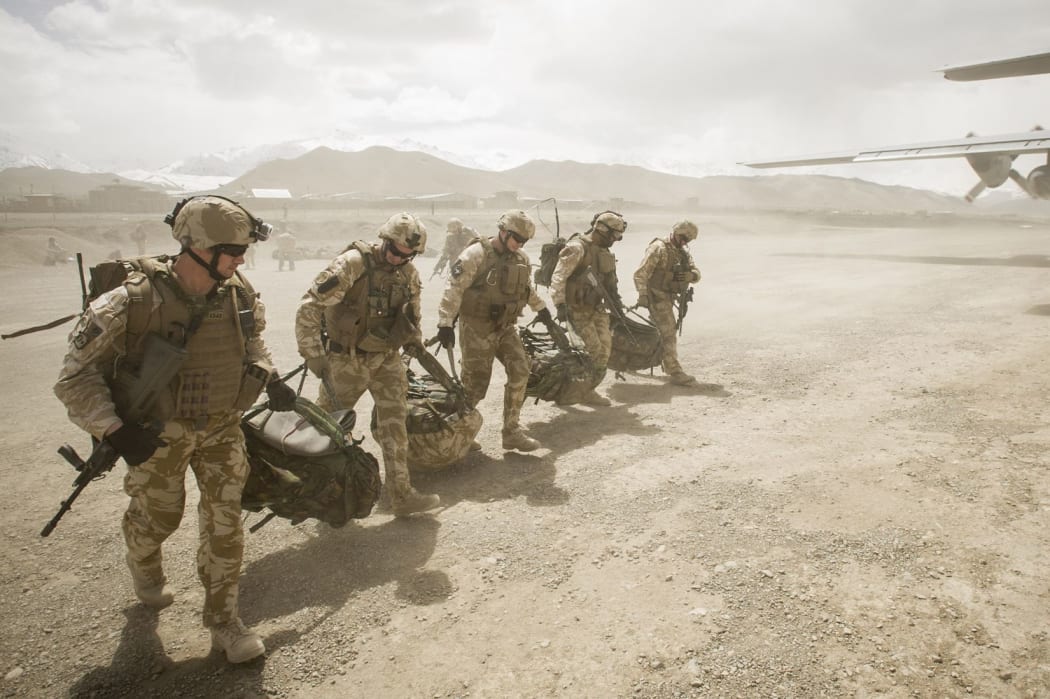 Departing soldiers carry gear to an RNZAF Hercules before leaving Bamyan province.