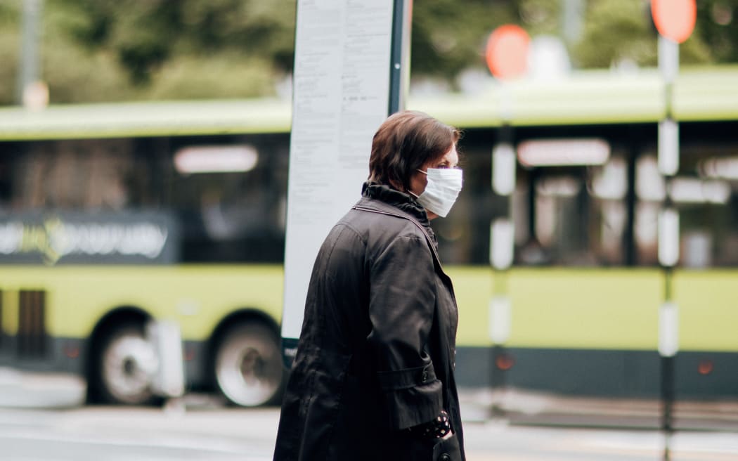 A pedestrian wearing a mask during level 2, Wellington 15 February 2021