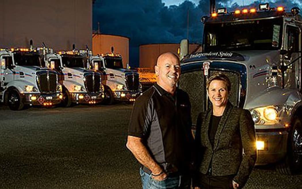 Couple stand in front of big trucks