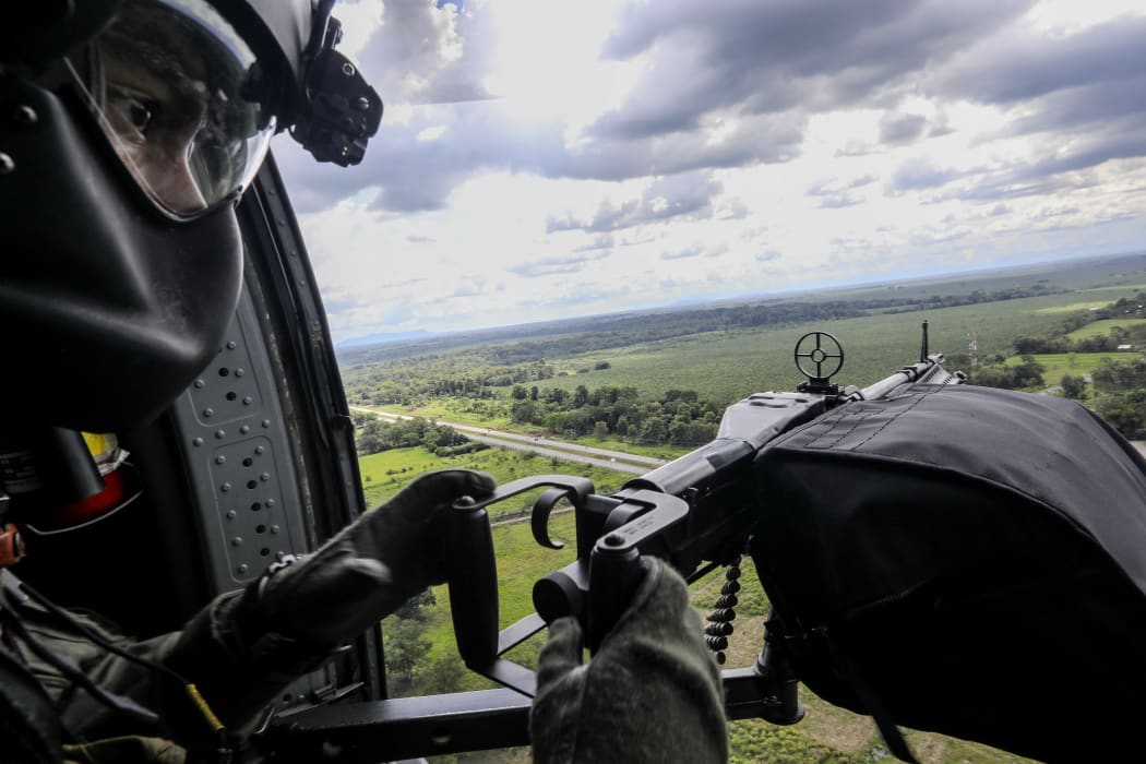 A Colombian Air Force soldier is pictured as he holds an alert position onboard a blackhawk helicopter overflying the Gulf of Uraba.
