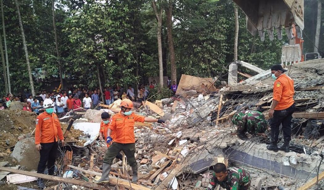 Search and rescue personnel try to rescue people trapped under the rubble of a collapsed building following an earthquake in Pidie, Aceh province, Indonesia on 7 December, 2016.