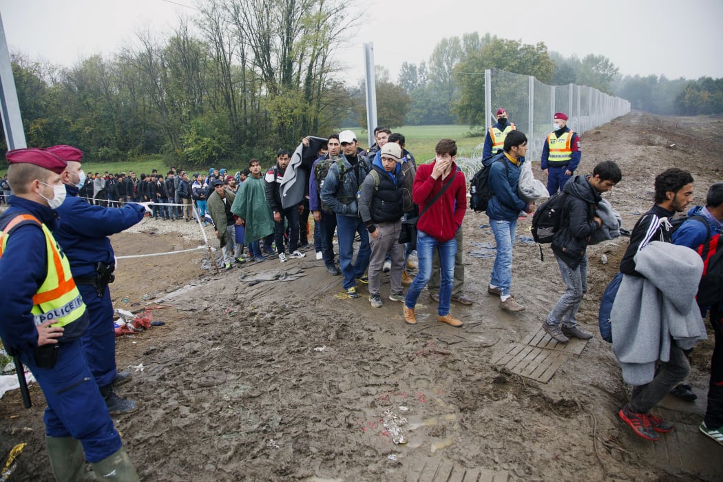 Hungarian police direct migrants after they cross the Hungarian-Croatian border, shortly before the border was closed, in October 2015..