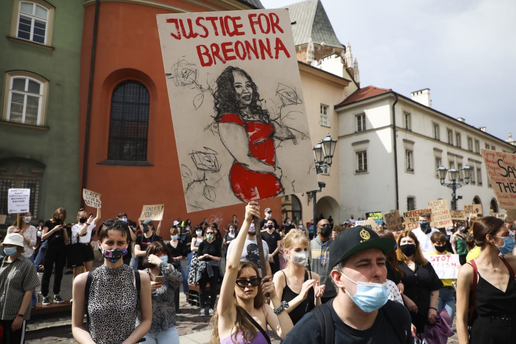 A sign picturing Breonna Taylor is displayed at a demonstration for George Floyd in Krakow.