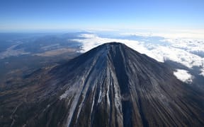 The first snowfall near the summit of Mount Fuji is observed above Yamanashi and Shizuoka Prefectures on November 7, 2024. The Kofu Regional Meteorological Observatory announced on November 7 that it had observed the first snowfall on Mount Fuji. This was 36 days later than the average to make the latest first snowfall in the past 130 years since statistics began being kept in 1894.( The Yomiuri Shimbun ) (Photo by Masahiro Sugimoto / Yomiuri / The Yomiuri Shimbun via AFP)