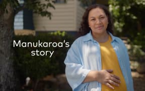 Pregnant woman in blue shirt and yellow teeshirt with hand on belly