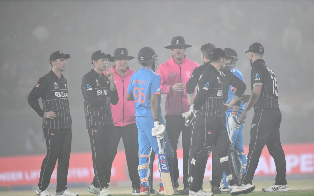 Players wait as misty conditions stops play during the Cricket World Cup match between India and New Zealand.