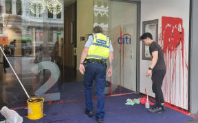 A police officer at the US consulate and MFAT building where red paint was poured on the walls of door outside on 14 November, 2023.