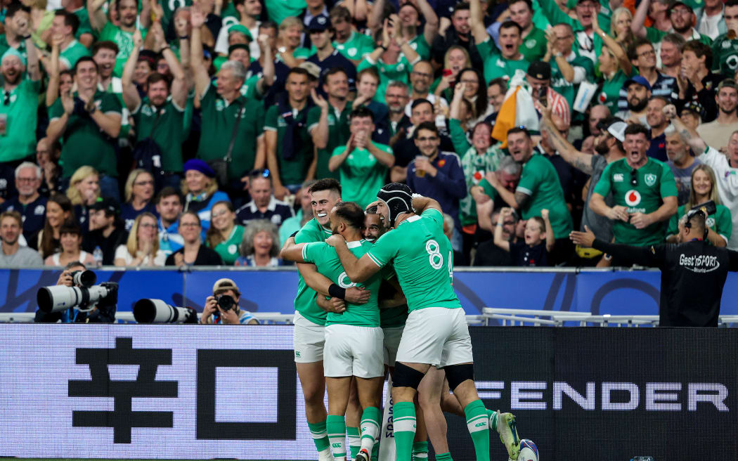 Irish rugby players celebrate in front of their fans.
