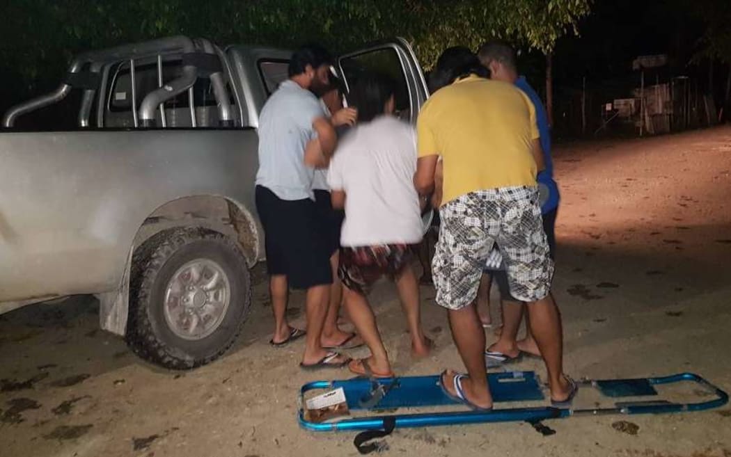 The refugee is loaded into a vehicle after collapsing at the detention centre.