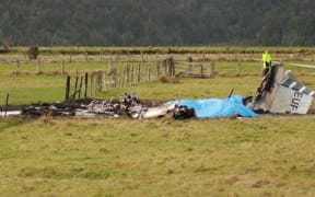 The wreckage of the crashed skydiving plane is seen at the end of the runway at Fox Glacier Airport on 4 September, 2010.