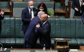 Australian Treasurer Josh Frydenberg hugs Prime Minister Scott Morrison (L) after delivering his 2022 Budget in Parliament House in Canberra on March 29, 2022.