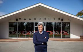 Te Maire Tau standing in front of Tauawhi marae.