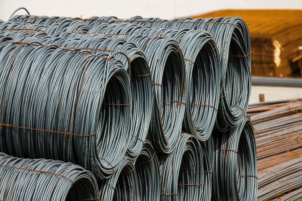 Steel sitting in a yard in an industrial area.