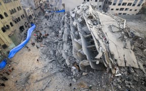 People inspect the ruins of a building destroyed in Israeli strikes in Gaza City on October 8, 2023. Fighting between Israeli forces and the Palestinian militant group Hamas raged on October 8, with hundreds killed on both sides after a surprise attack on Israel prompted Prime Minister Benjamin Netanyahu to warn they were "embarking on a long and difficult war".