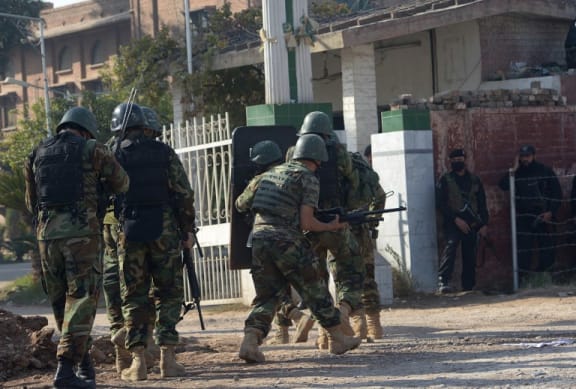 Pakistani soldiers enter an Agriculture Training Institute after an attack by Taliban militants in Peshawar.