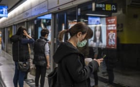 A woman wears a mask as she waits for an MTR Train on a platform in Tsim Sha Tusi on January 22, 2019 in Hong Kong, China.