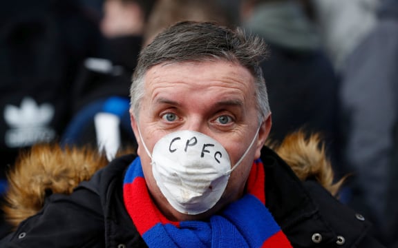 Crystal Palace fan poses with a dusk mask inside Selhurst Park due to the global outbreak of COVID-19 coronavirus