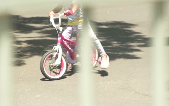 A child on a bike at an emergency accommodation motel.