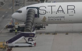 A Singapore Airlines Boeing 777-300ER aircraft is seen parked at Suvarnabhumi International Airport, near Bangkok, Thailand, on Wednesday, 22 May, 2024 after the SQ321 London-Singapore flight encountered severe turbulence. The flight descended 6000 feet (around 1800 meters) in about three minutes, the carrier said. A British man died and authorities said dozens of passengers were injured, some severely.