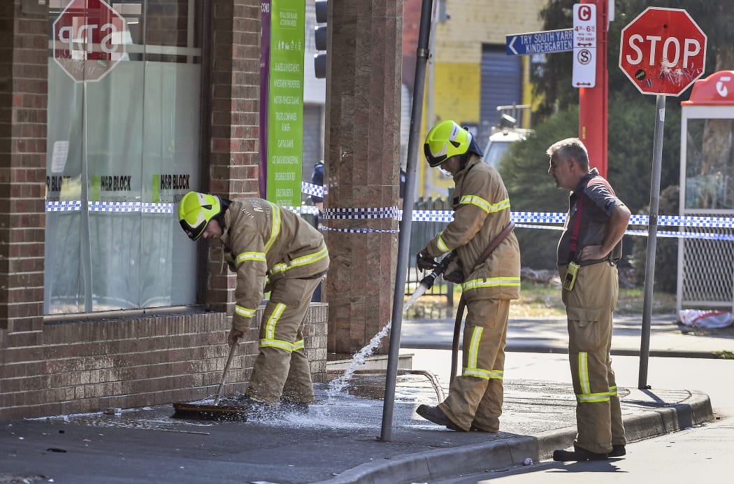 Firemen wash away bloodstains after a security guard was shot dead with another man fighting for his life after a drive-by shooting outside a popular Melbourne nightclub.