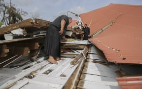 Deputy Clerk Sione Vikilani (left) and Lord Fakafanua (right) survey the damaged Parliament.