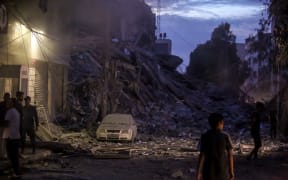 A Palestinian boy standing in front of the wreckage left after Israeli air strikes destroyed this 14-storey residential tower in the Al-Rimal neighborhood of Gaza City.