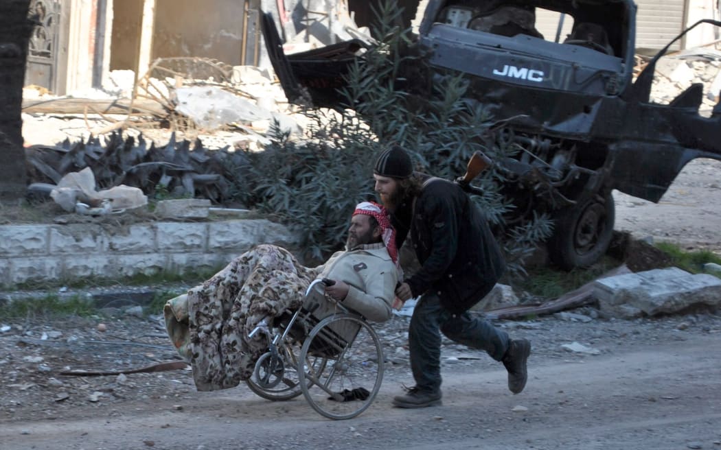 A man is helped in the beseiged city of Homs. Violence in Syria has driven  9.5 million people from their homes.
