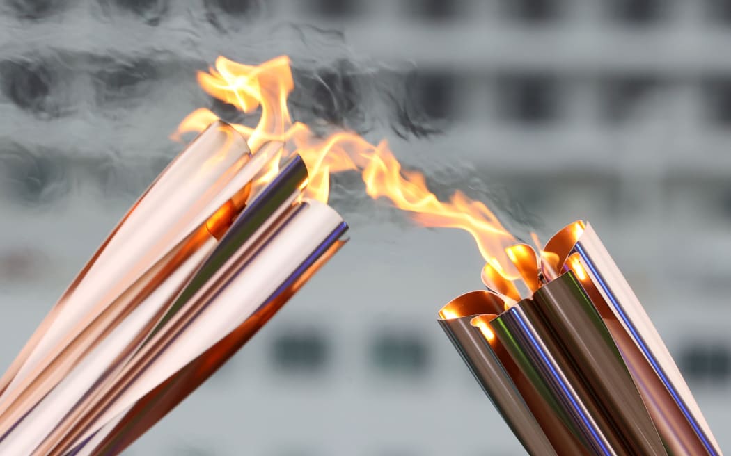 Olympic flame is passed from a torch to another torch, Japan, 2021.