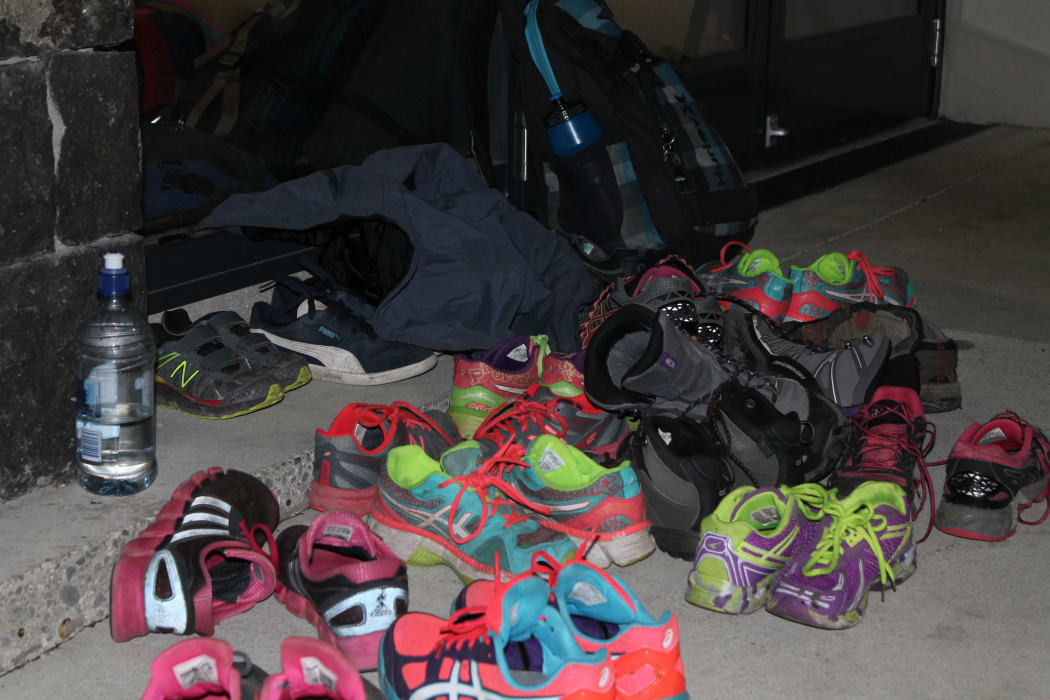 A photo of all the group's shoes piled up outside the school hall