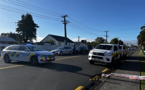 Police vehicles and emergency tape at a Rathgar Road, Henderson, property where a person died in a house fire, 8 February 2024.
