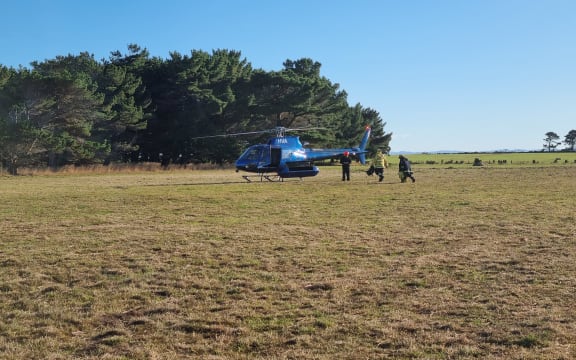Firefighters have to be ferried out to the Awarua Bay fire by helicopter.