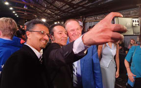 Former Prime Minister John Key greets party supporters during the National election night event.