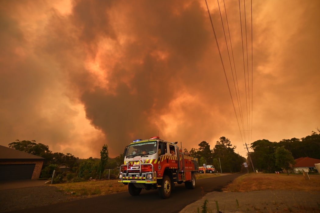Firetrucks are seen stationed on a road as a bushfire burns in Bargo, southwest of Sydney on December 21, 2019.