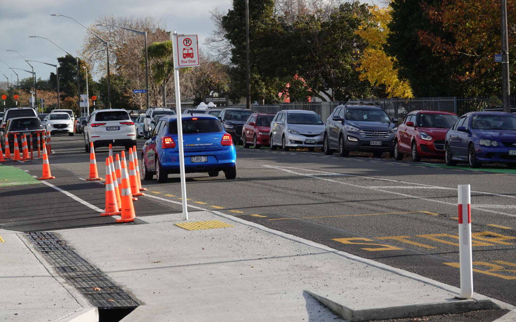 Vehicles on the far side of the road park in the cycleway. It's intended that barriers would prevent this, but construction on the project has paused.