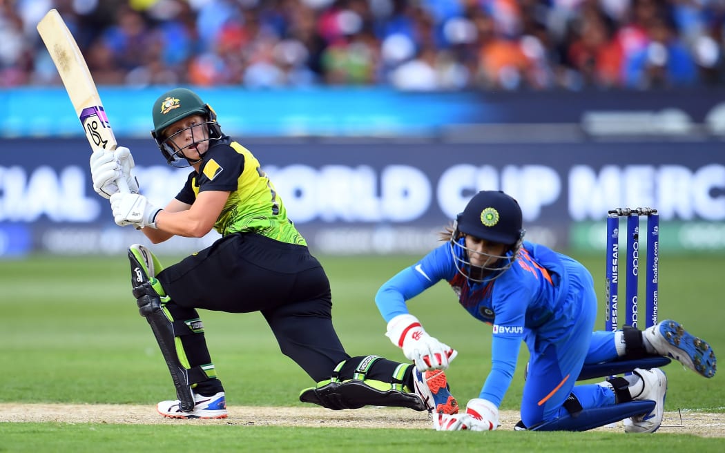 Australia's Alyssa Healy (L) plays a shot as India's wicketkeeper Taniya Bhatia follows the ball during the Twenty20 women's World Cup cricket final match between Australia and India in Melbourne on March 8, 2020.