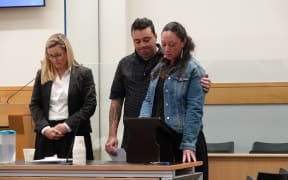 Alicia Toki reads her victim impact statement, with partner Andre Petera and lawyer Ellie Harrison.