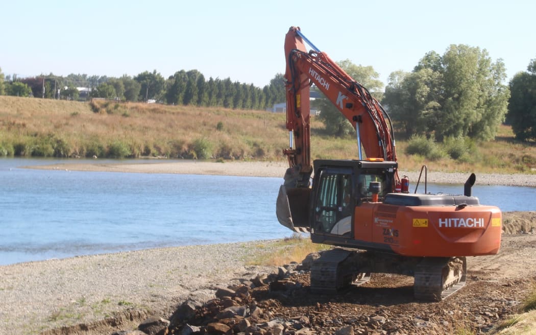 A digger on a stopbank in Mataura, Southland.