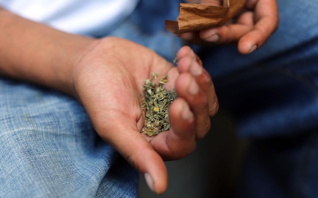 NEW YORK, NY - AUGUST 05: A man prepares to smoke K2 or "Spice", a synthetic marijuana drug, along a street in East Harlem on August 5, 2015 in New York City. New York, along with other cities, is experiencing a deadly epidemic