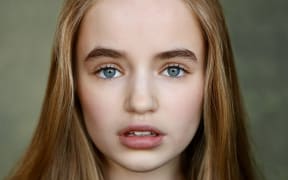 Nell Fisher is a young girl with pale skin, long brown hair and blue eyes.